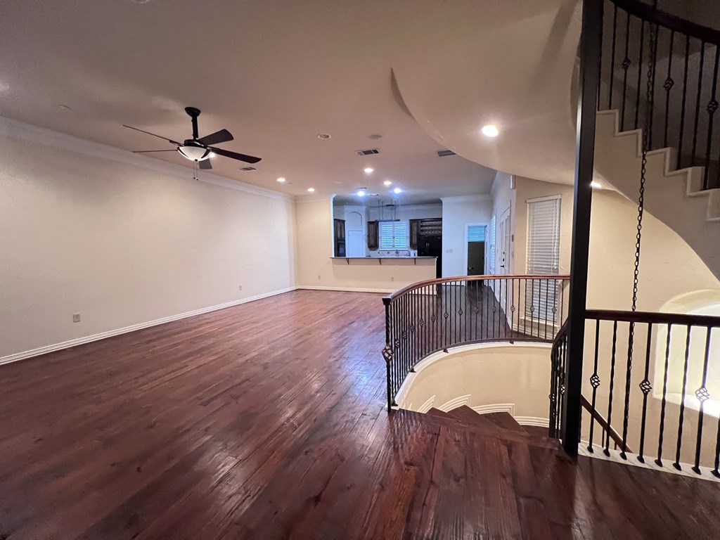 A room with a wooden floor and a ceiling fan.