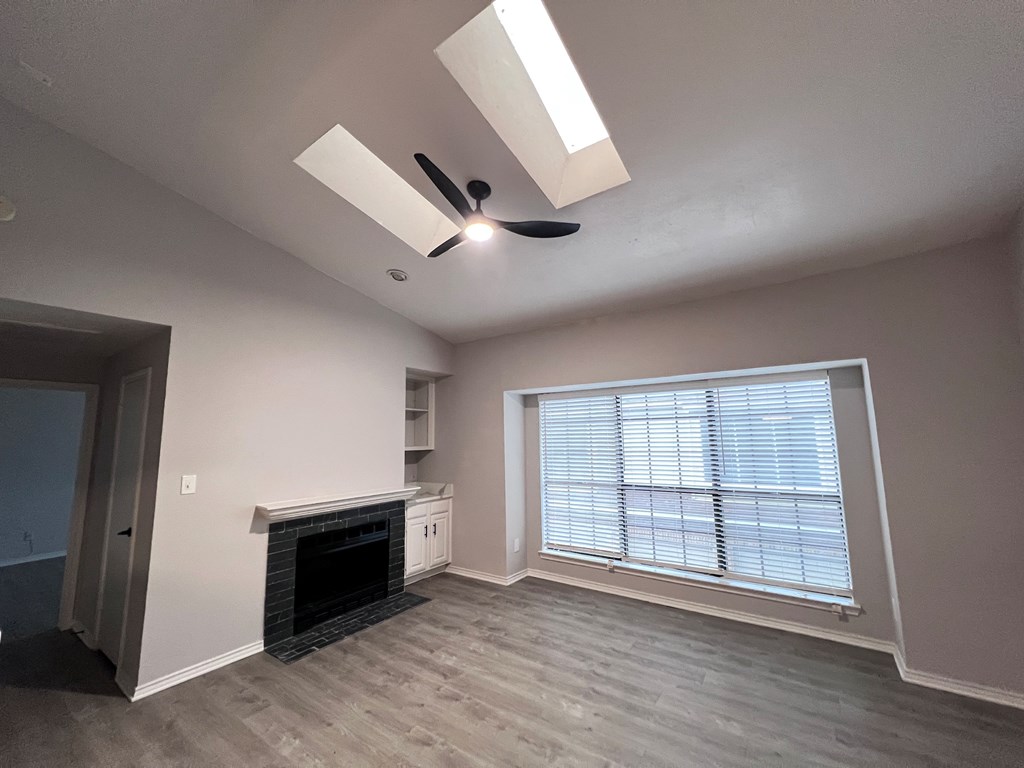 A room with a fireplace and a window with blinds.