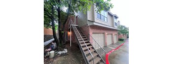 A house with a red painted driveway and a garage door.