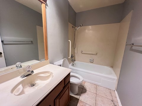 A bathroom with a sink, toilet, and bathtub.