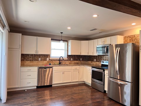 A kitchen with white cabinets and stainless steel appliances.
