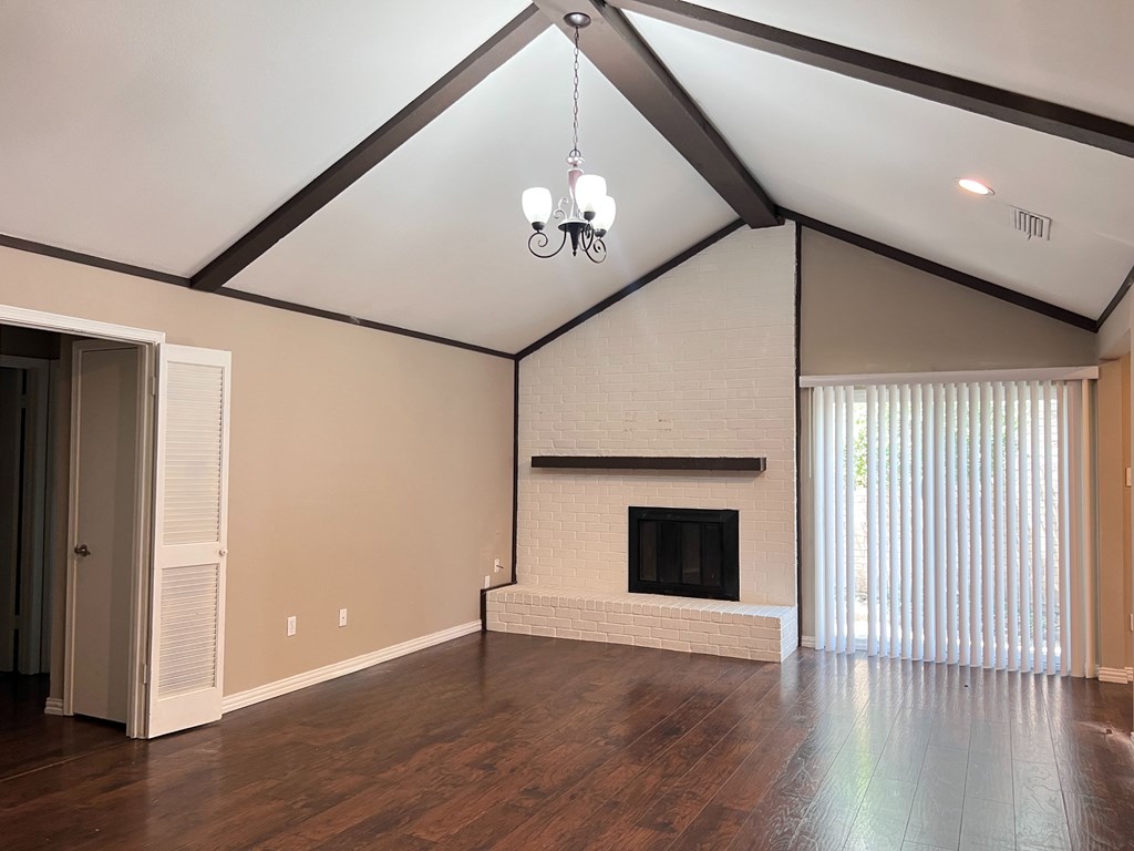 A living room with a fireplace and wood flooring.