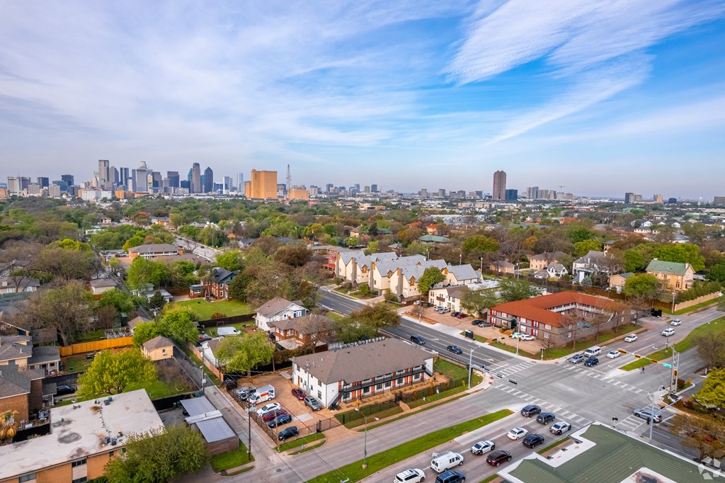A cityscape with a mix of residential and commercial buildings, with a clear sky above.
