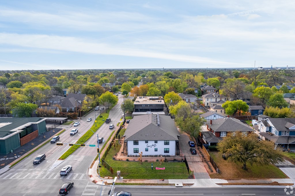 A view of a street with cars and houses.