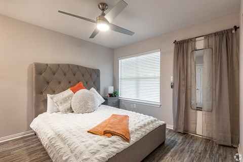 A bedroom with a large bed and a ceiling fan.