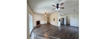 A spacious living room with a fireplace and hardwood floors.