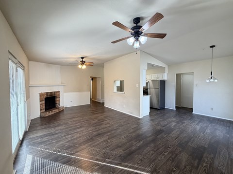 A spacious living room with a fireplace and hardwood floors.