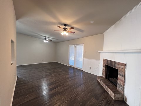 A room with a fireplace and a ceiling fan.