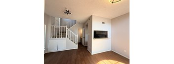 A room with a staircase and a flat screen TV.