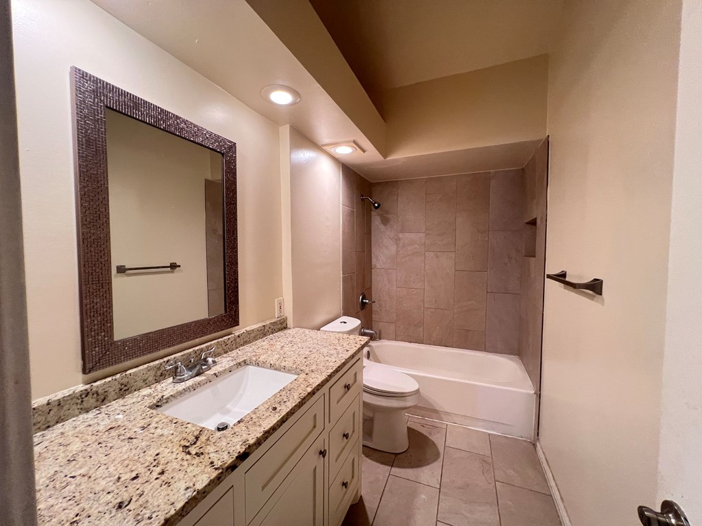 A bathroom with a sink, toilet, and bathtub.
