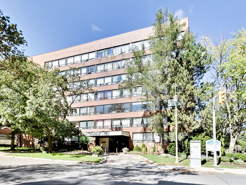 A large building with a lot of windows and trees in front.