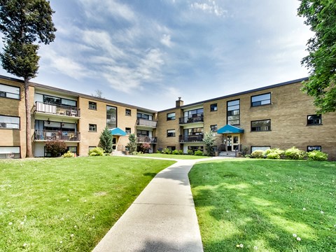 A grassy area in front of apartment buildings.