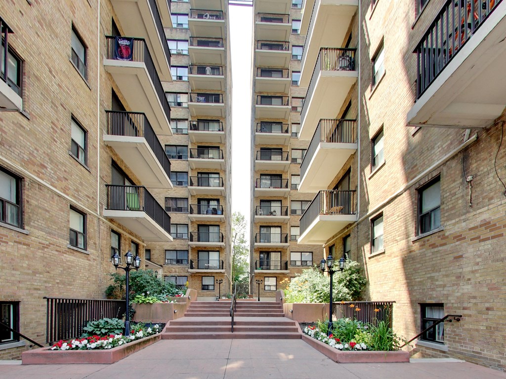 a view of a courtyard between two tall apartment buildings