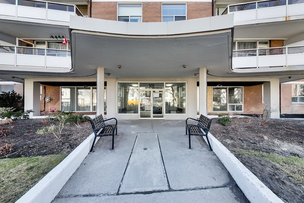 A building with a white overhang and two black benches in front.
