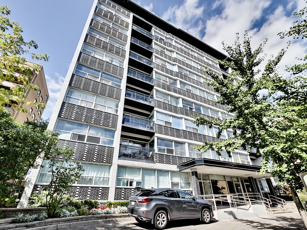 a car parked in front of an apartment building