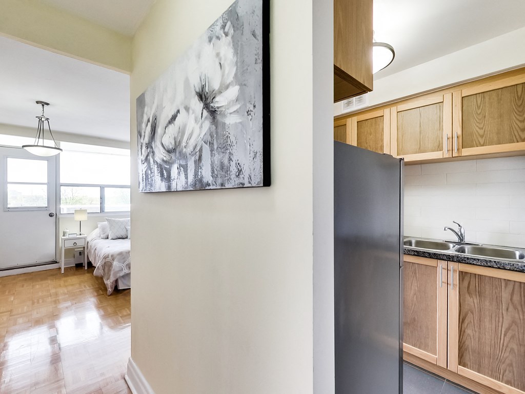 A modern kitchen with a large painting on the wall.