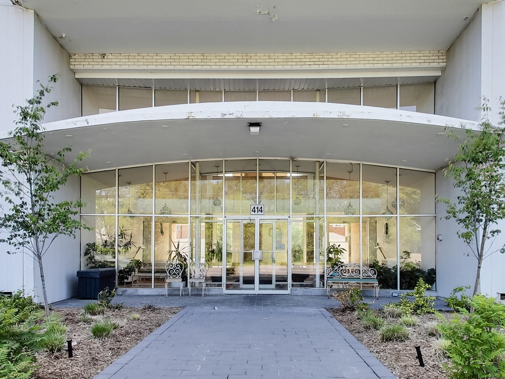 the entrance of a building with glass doors and a courtyard