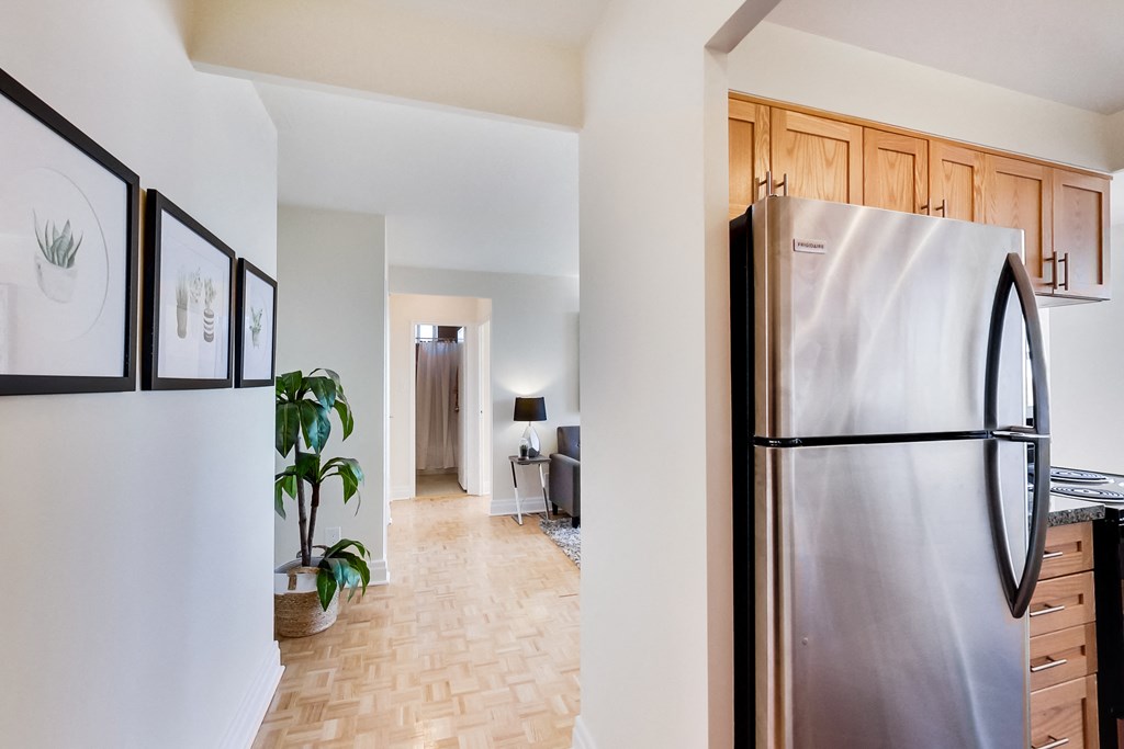 A modern kitchen with a stainless steel refrigerator and wooden cabinets.