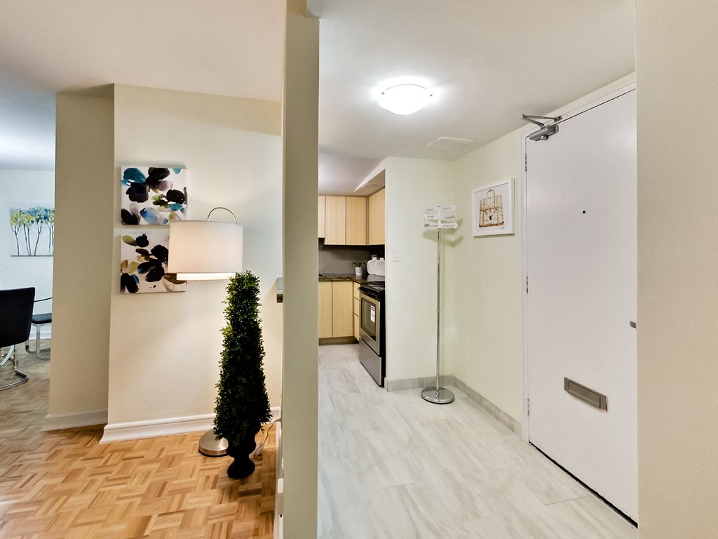 A white fridge in a kitchen with a white wall and a white floor.