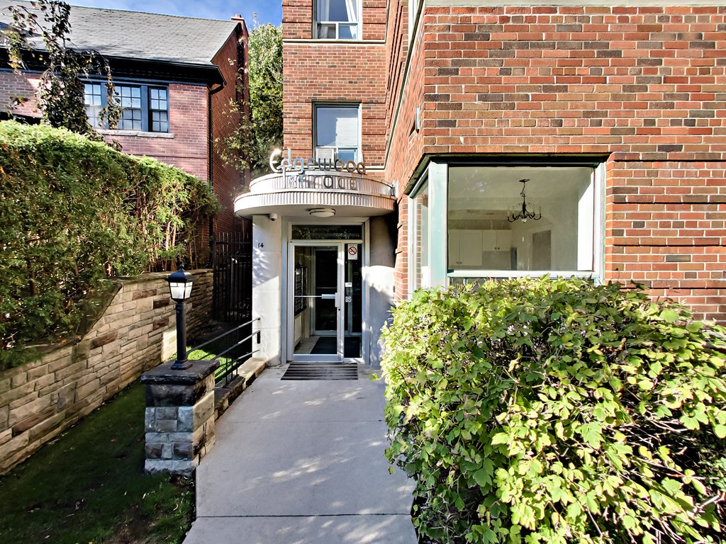 A brick building with a white awning and a glass door.