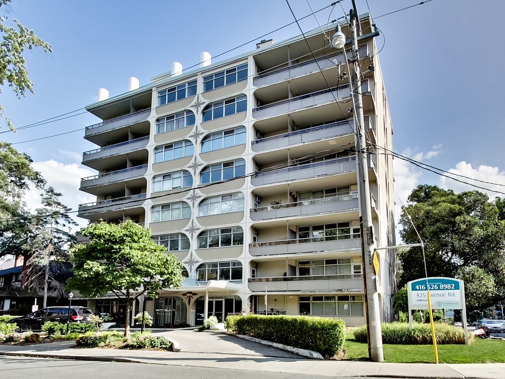 A tall residential building with a sign in front of it.