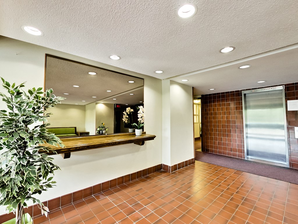 a lobby with a large mirror and a plant