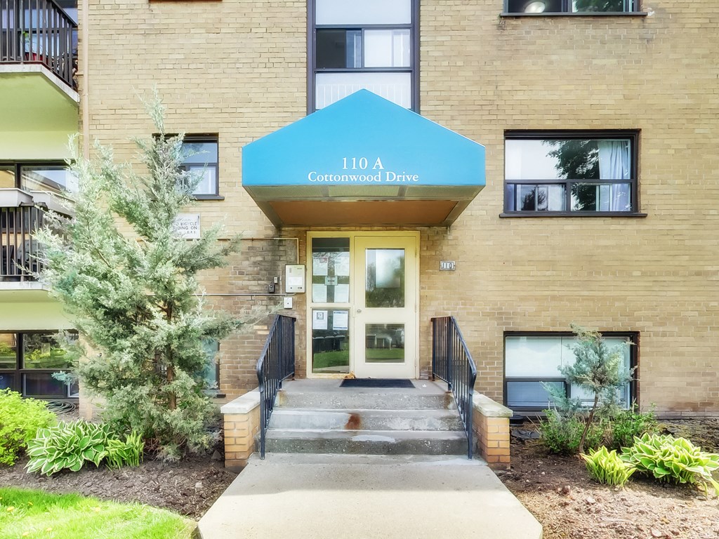 The front of a building with a blue awning that says Cottonwood Drive.