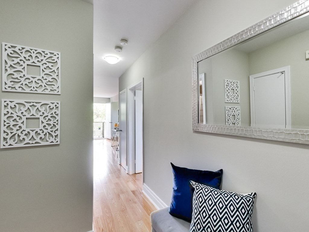 A hallway with a mirror and two decorative panels on the wall.