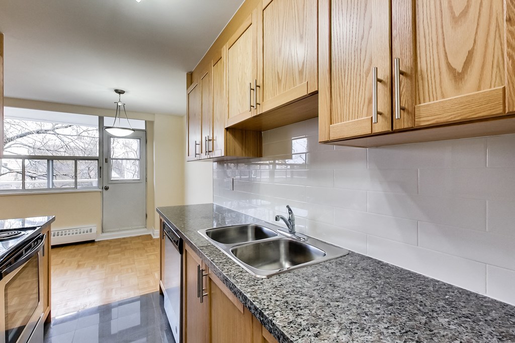 A kitchen with wooden cabinets and a granite countertop.
