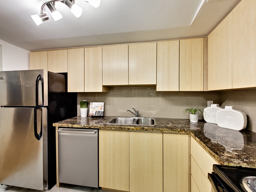 A kitchen with wooden cabinets and a granite countertop.