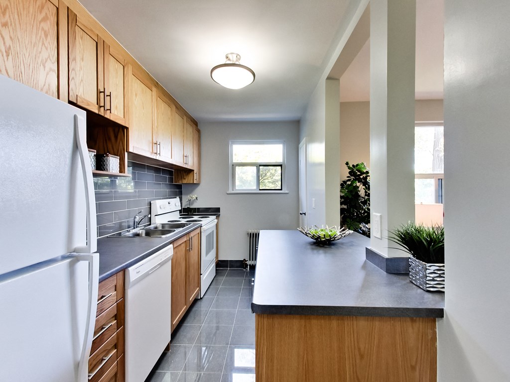 A kitchen with a white refrigerator and wooden cabinets.