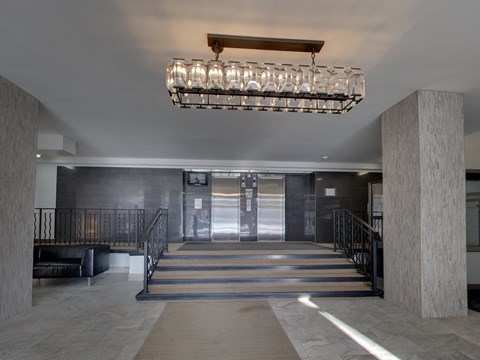 a lobby with a staircase and a large chandelier
