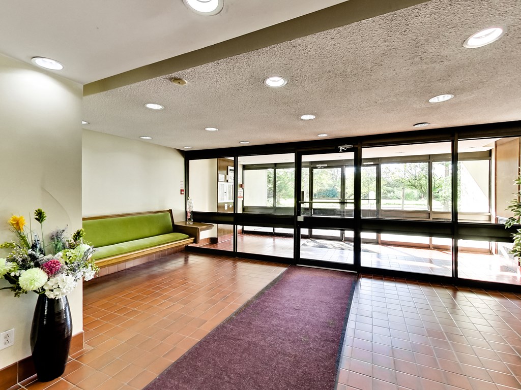 a lobby with a purple rug and a green couch