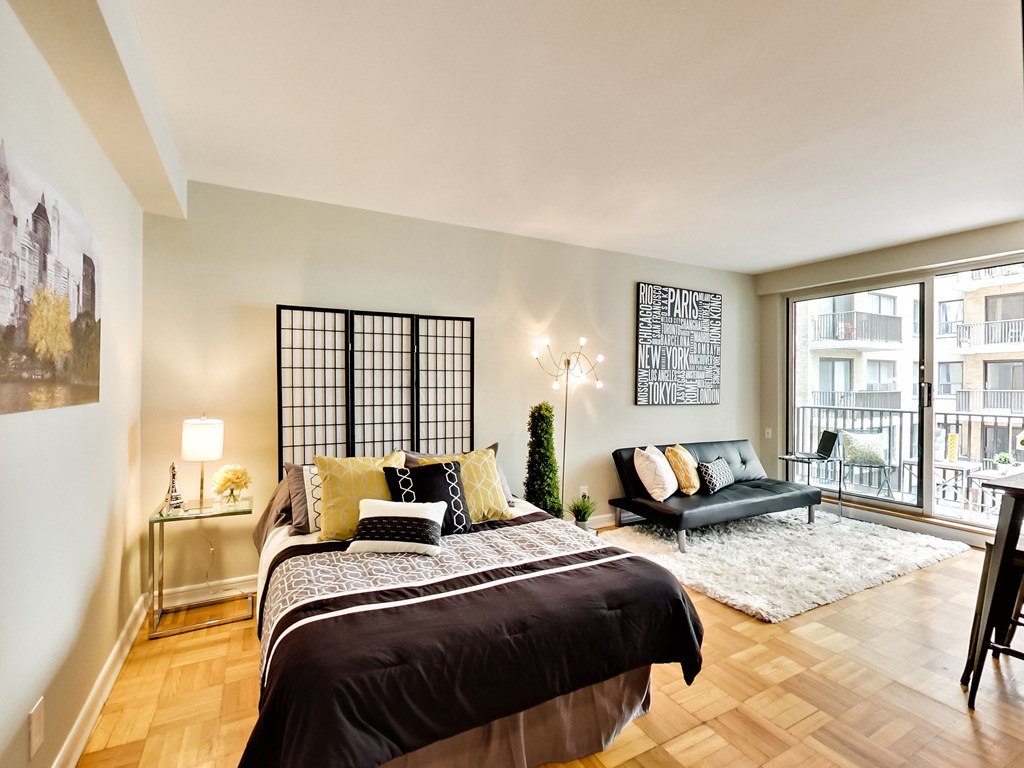 a bedroom with a bed and a couch and a window