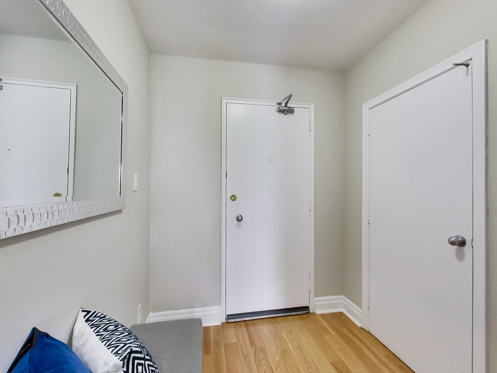 A white door with a silver handle is in the middle of a room.