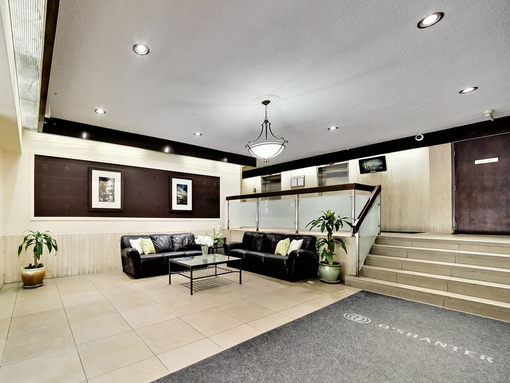 A living room with a couch, a coffee table, and a staircase.