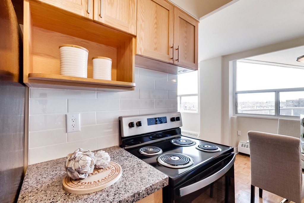 A kitchen with a stove and a chair.
