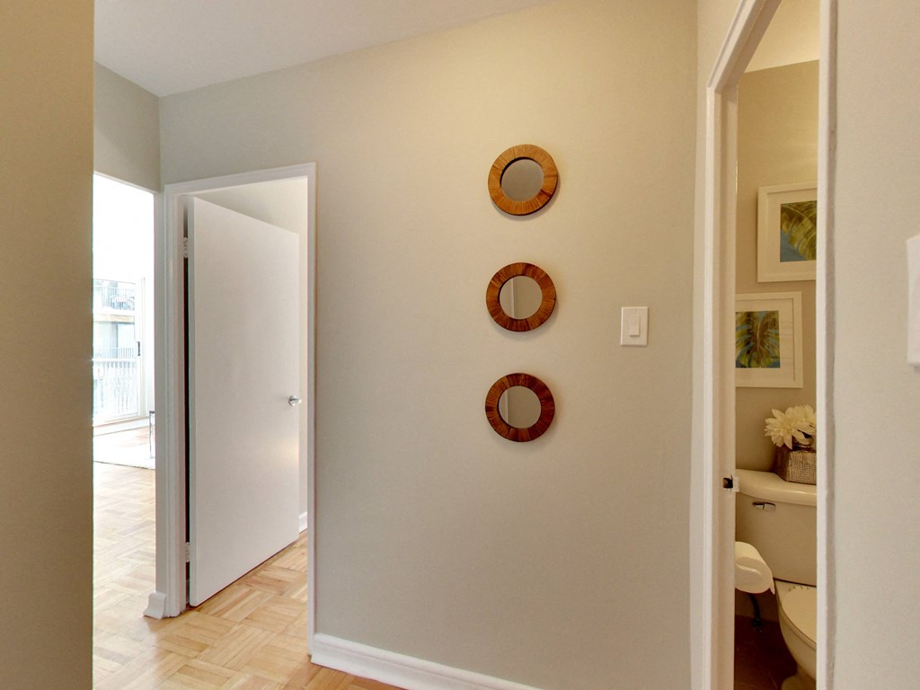 a hallway with three round mirrors on the wall