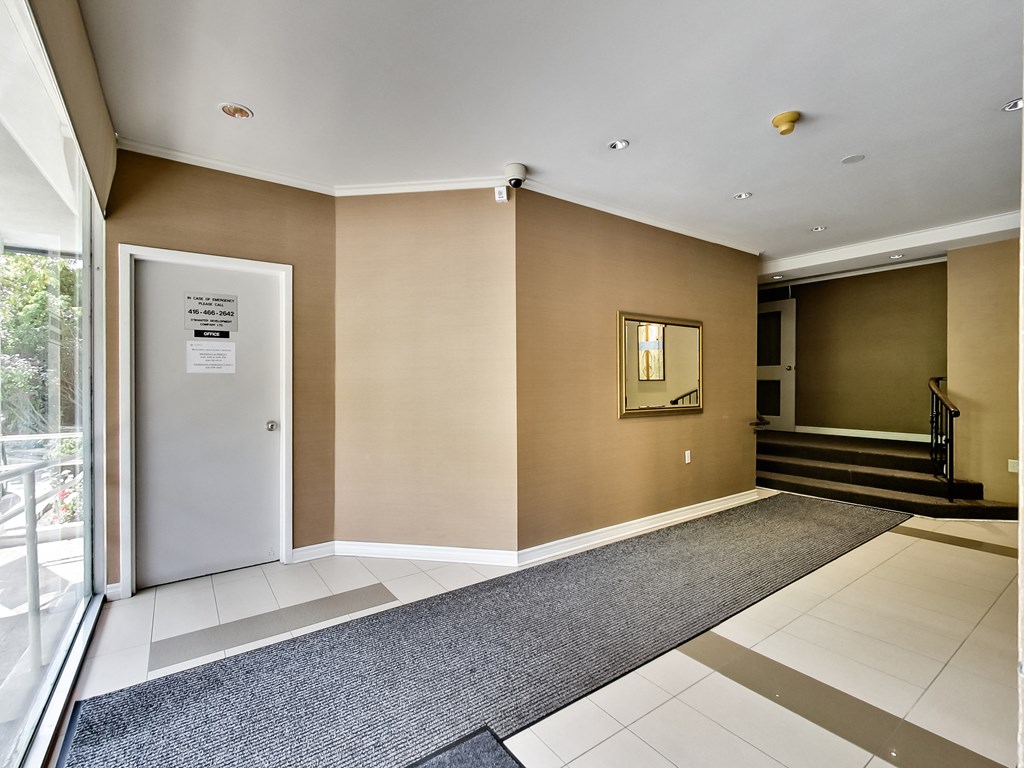 a lobby with a door and a carpeted floor and a staircase
