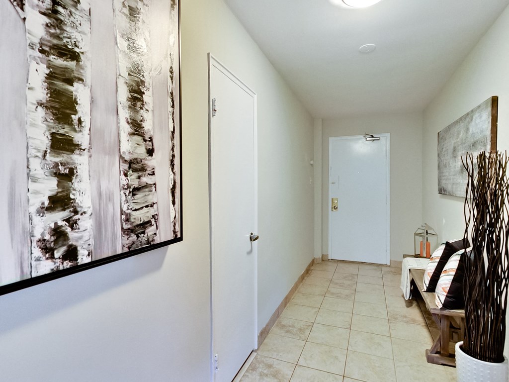a hallway with a white door and a painting on the wall