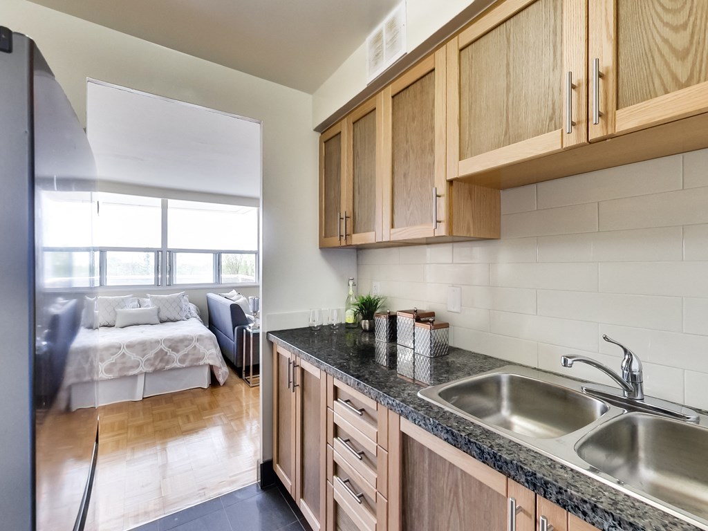 A kitchen with wooden cabinets and a black countertop.