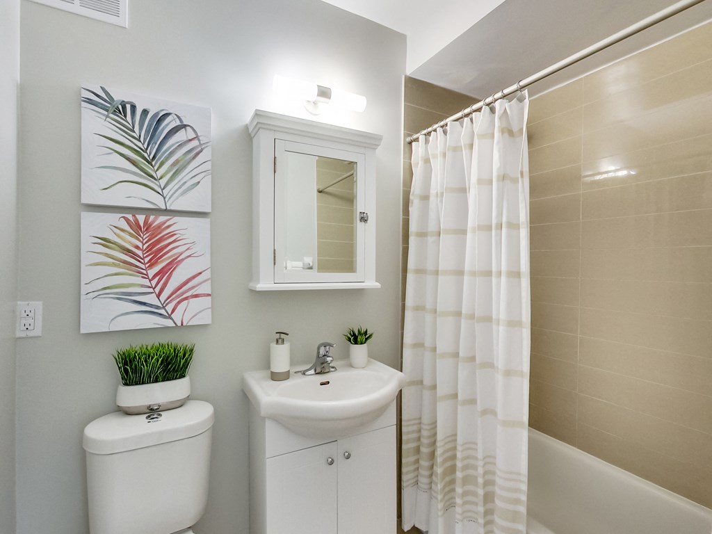 A white toilet sits next to a white sink in a bathroom.