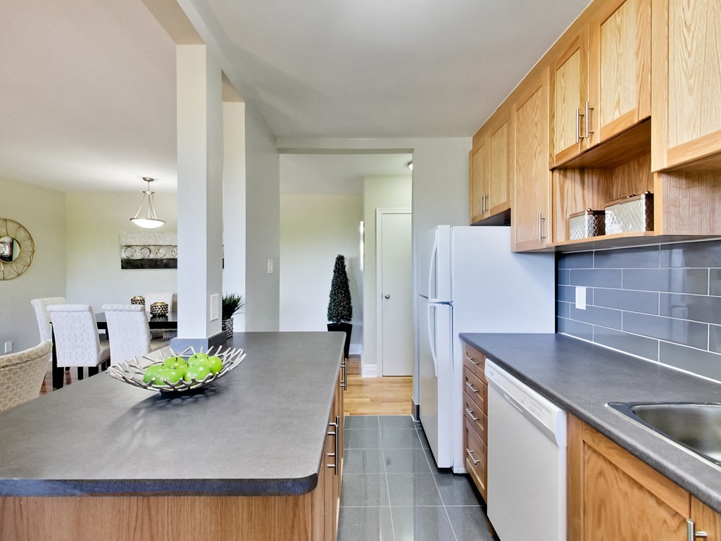 A kitchen with a bowl of fruit on the counter.