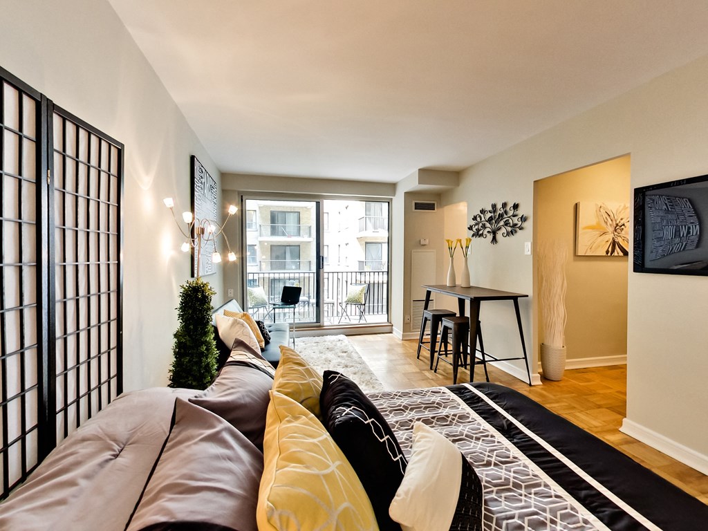 a living room with a couch and a tv and a dining room and a balcony