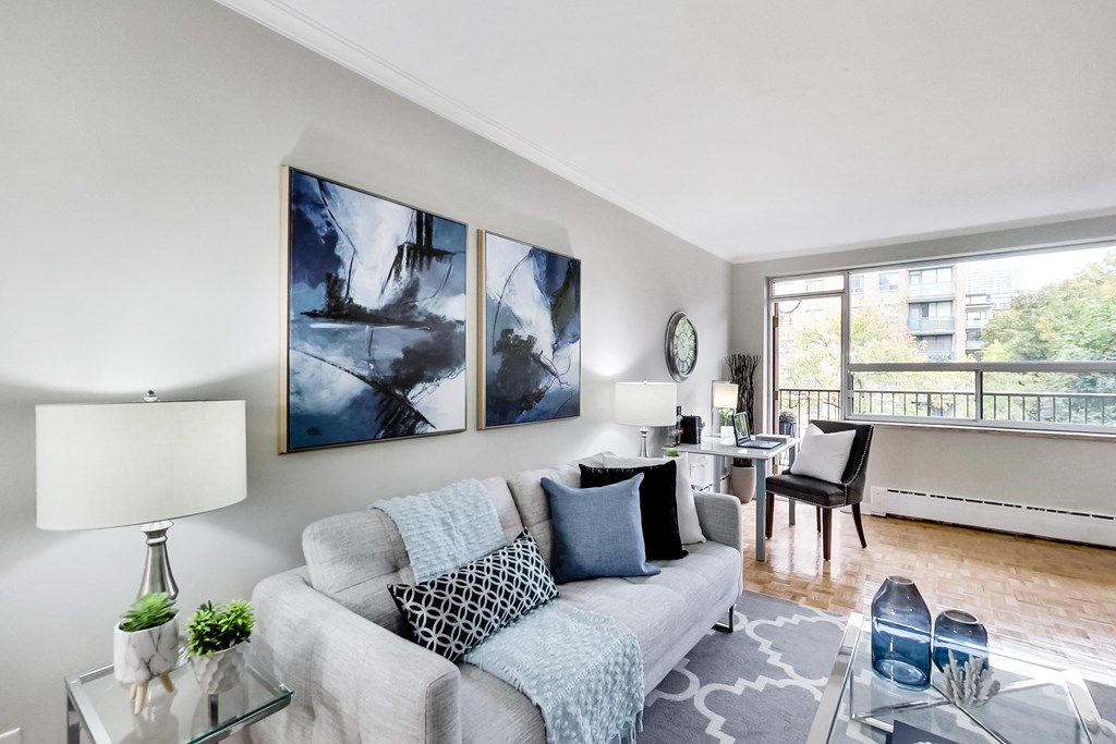 a living room with a couch and a table with a chair and a window