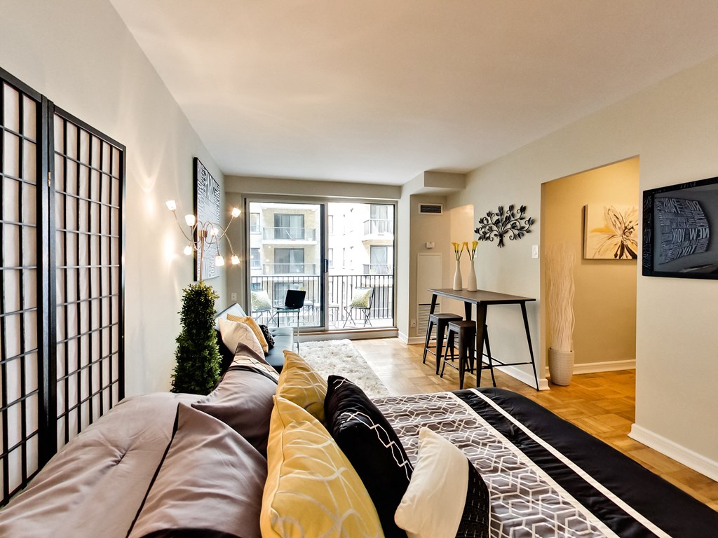 a living room with a couch and a tv and a dining room and a balcony
