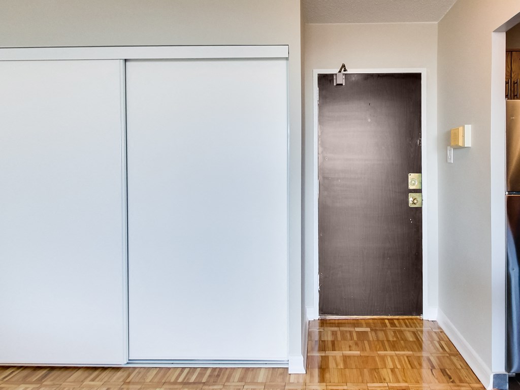a hallway with white walls and a black door