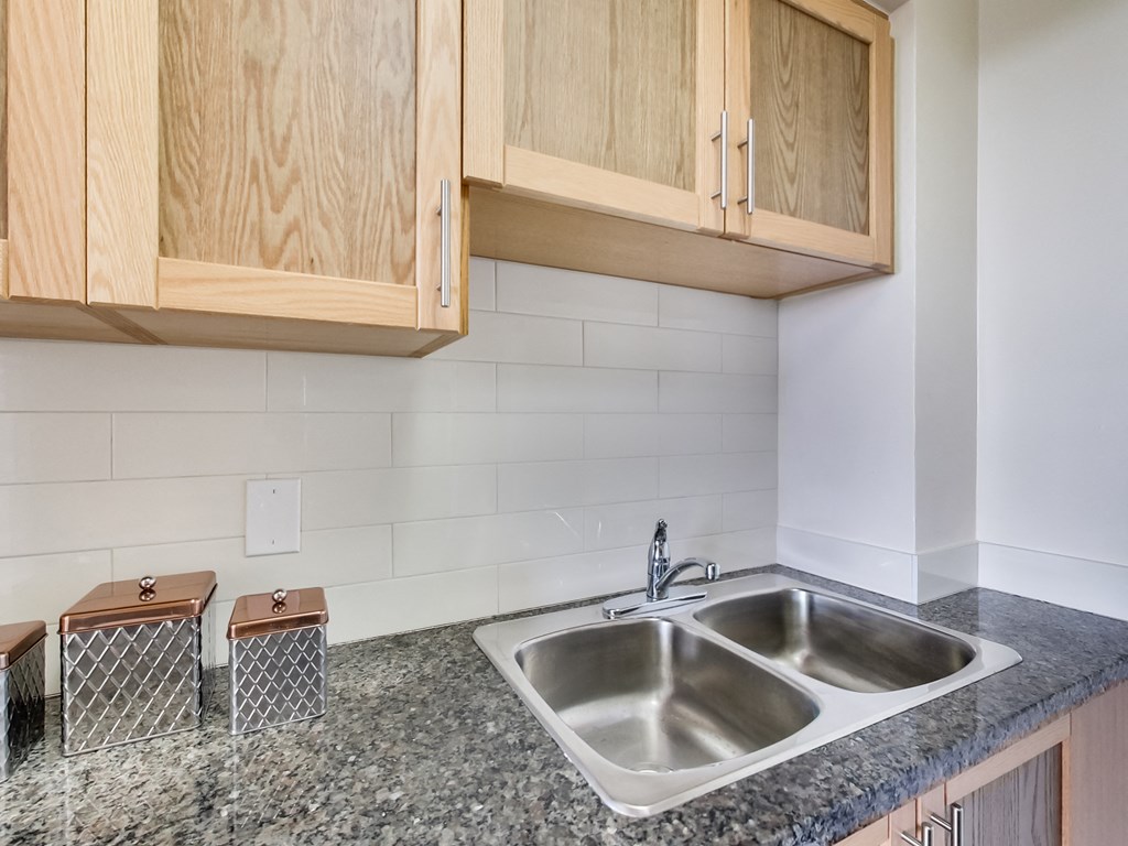 A kitchen with a sink and wooden cabinets.