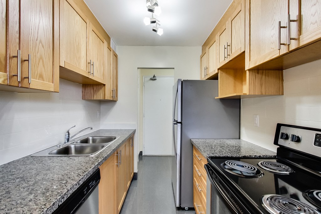 A kitchen with wooden cabinets and a black stove top oven.
