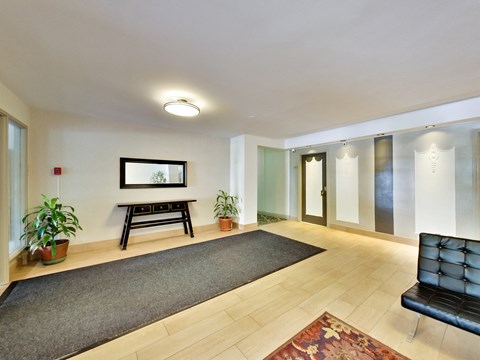 a living room with a rug and a black couch and a table